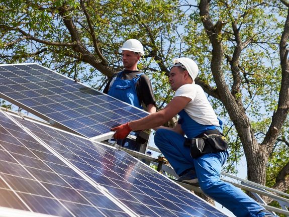 Arbeiter installieren ein Solarpanel. SWS Netze, Neuanlagen.